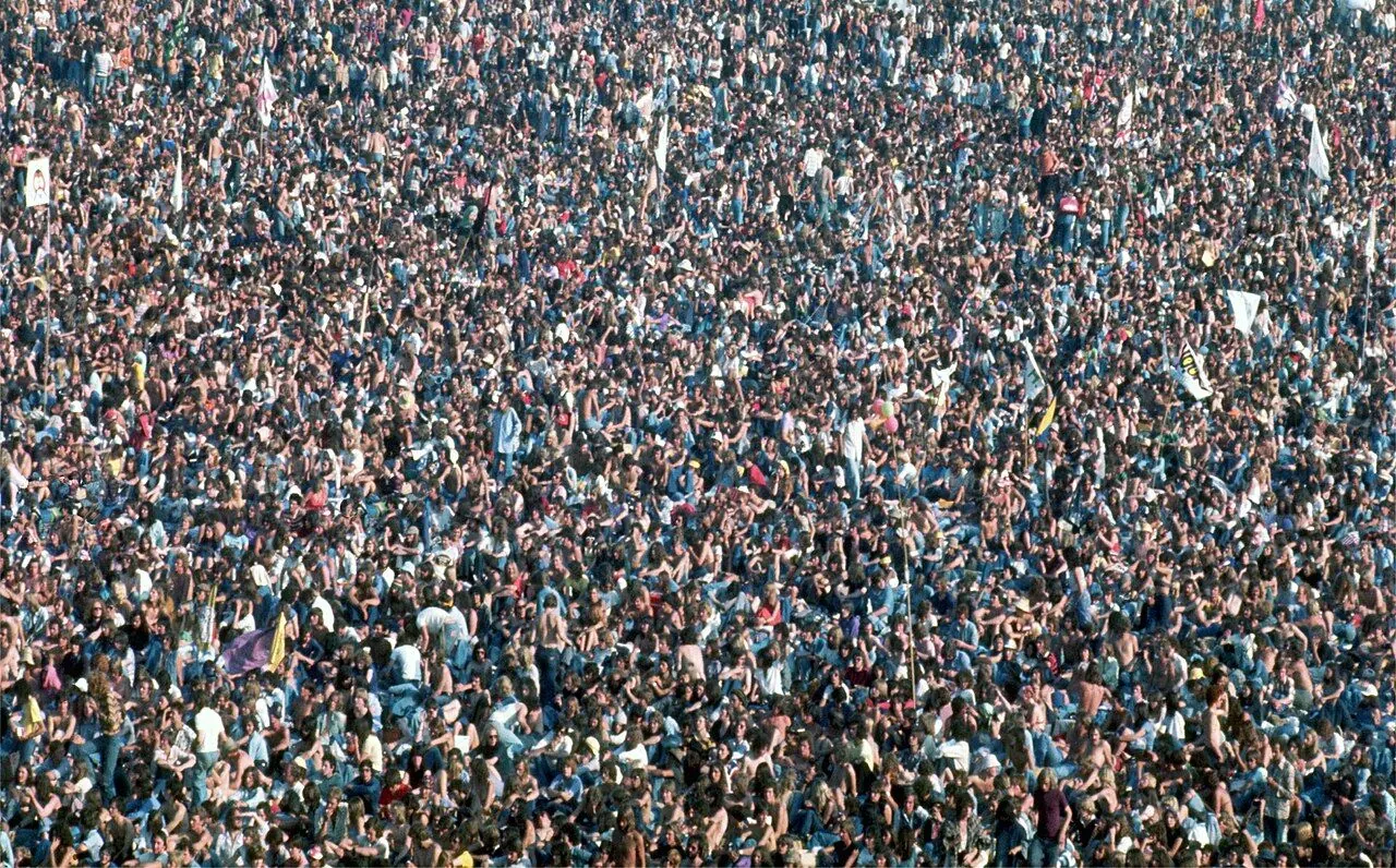 Crowd facing a lit stage at a sold-out gig