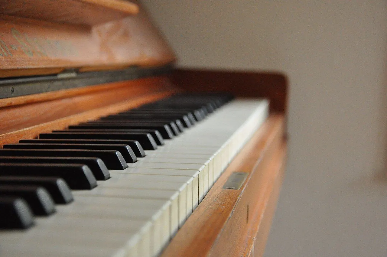 Musician wearing headphones listening closely at a keyboard